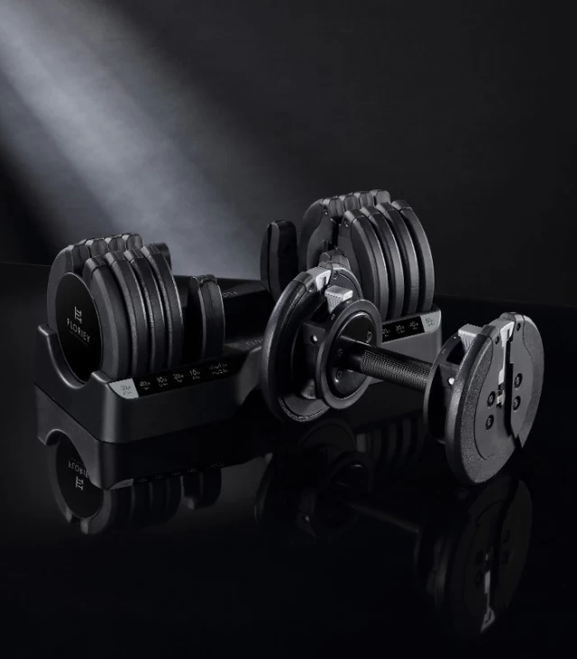 Black 55 lb adjustable dumbbell in the T9 series on a black surface.