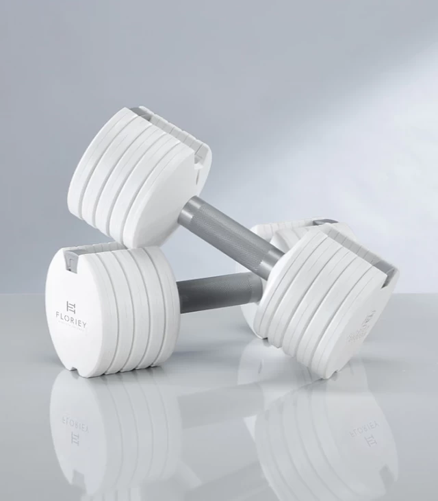 12.5lb white adjustable dumbbells on a reflective surface, ideal for home gym